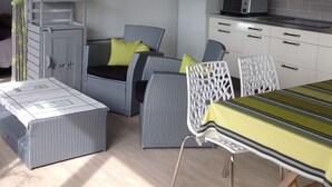 Una habitación compacta con kitchenette, una cama con dosel, una mesita y una silla.