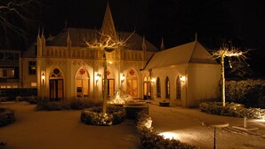 A snow-covered courtyard with a building featuring pointed roofs and arched windows. - Exclusive location in an oasis of tranquillity in Hoorn (near Amsterdam).  (Hoorn NH)
