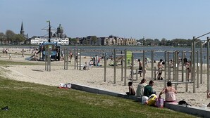 A beach with people, a playground, and buildings in the background. - Exclusive location in an oasis of tranquillity in Hoorn (near Amsterdam).  (Hoorn NH)