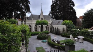 A courtyard with a church, seating area, and well-maintained greenery. - Exclusive location in an oasis of tranquillity in Hoorn (near Amsterdam).  (Hoorn NH)