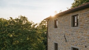 A stone building with a wooden staircase leading up to it, surrounded by greenery. - Villa Santarsa, 31 people, magnificent views and private pool, no neighbors (Sansepolcro)
