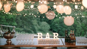 A bar setup with a wooden table, glasses, bottles, and a sign that reads "BAR". - Villa Santarsa, 31 people, magnificent views and private pool, no neighbors (Sansepolcro)