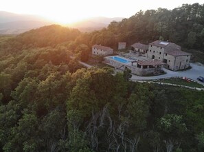 A stone building with a swimming pool surrounded by trees. - Villa Santarsa, sleeps 31, stunning views and a private pool, no neighbors (Sansepolcro)