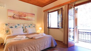Een slaapkamer met een bed, een schilderij, een raam en een balkon.