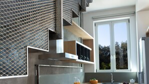 A modern kitchen with a built-in oven, a dishwasher, and a window providing natural light. - Aggelos Brand New Exclusive Villa with Private Pool (Agrikies Villas) (Lefkada)