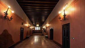A hallway with wooden paneling, a checkered floor, and wall-mounted sconces. - Lovely and quite apartment with garden in the heart of Venice (Venice)