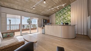 A modern kitchen with a wooden island, a dining area with a round table, and a balcony with a view.