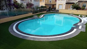 A circular swimming pool with a surrounding walkway, surrounded by artificial grass and a metal railing. - Detached Sea View Villa on Gated Development. (Antigua)