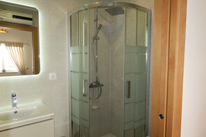 Regadera, secadora de cabello, toallas, papel de baño 