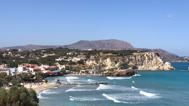 A coastal town with a beach, rocky cliffs, and a mountain in the background. - ☀️Stella Apartment☀️Almyrida 350m from the Sea, you don't rent a Car (Almyrida)