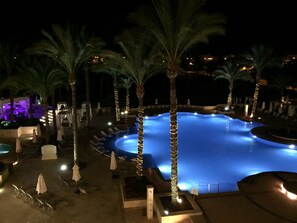 A nighttime view of a swimming pool surrounded by palm trees and lounge chairs. - Fabulous Villa on Golf Resort, Private Pool. (Torre-Pacheco)