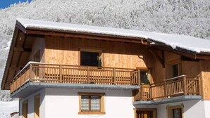 A wooden chalet with a balcony, surrounded by snow-covered trees. - Apartment la Ranche, Montriond (Montriond)