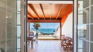 A balcony with a wooden ceiling, a table, chairs, and a view of the sea. - Private, independent villa on the first line, terrace and tranquility
 (La oliva)