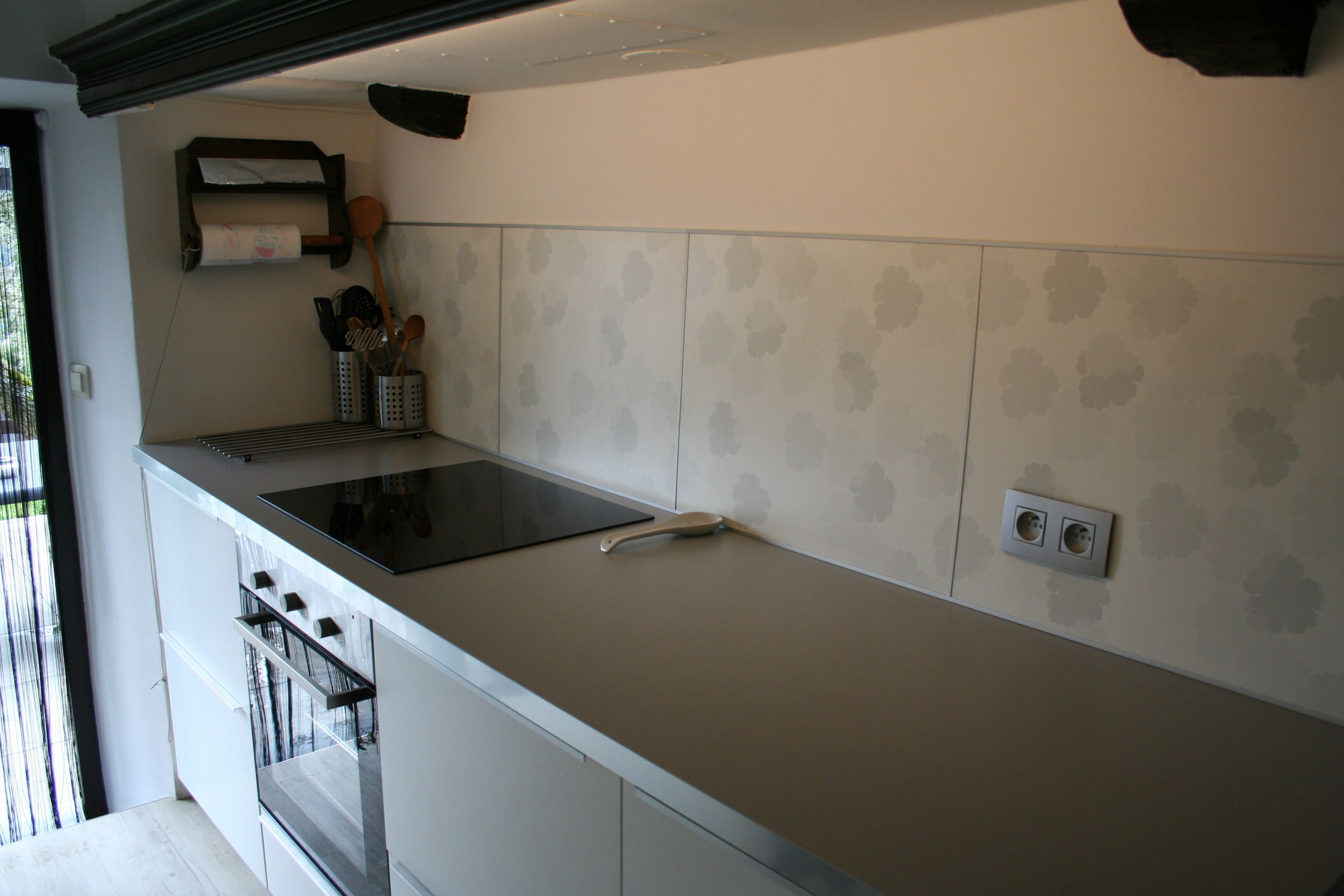 Een moderne keuken met een ingebouwde kookplaat, oven en aanrecht.
