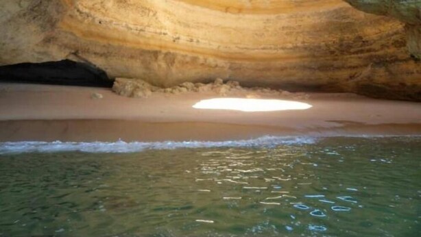A natural cave formation with a sandy beach and clear water. - Spacious Contemporay apartment in an independent villa (Porches)