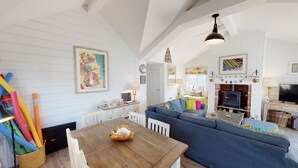 A cozy living room with a wooden table, a blue sofa, and a fireplace.