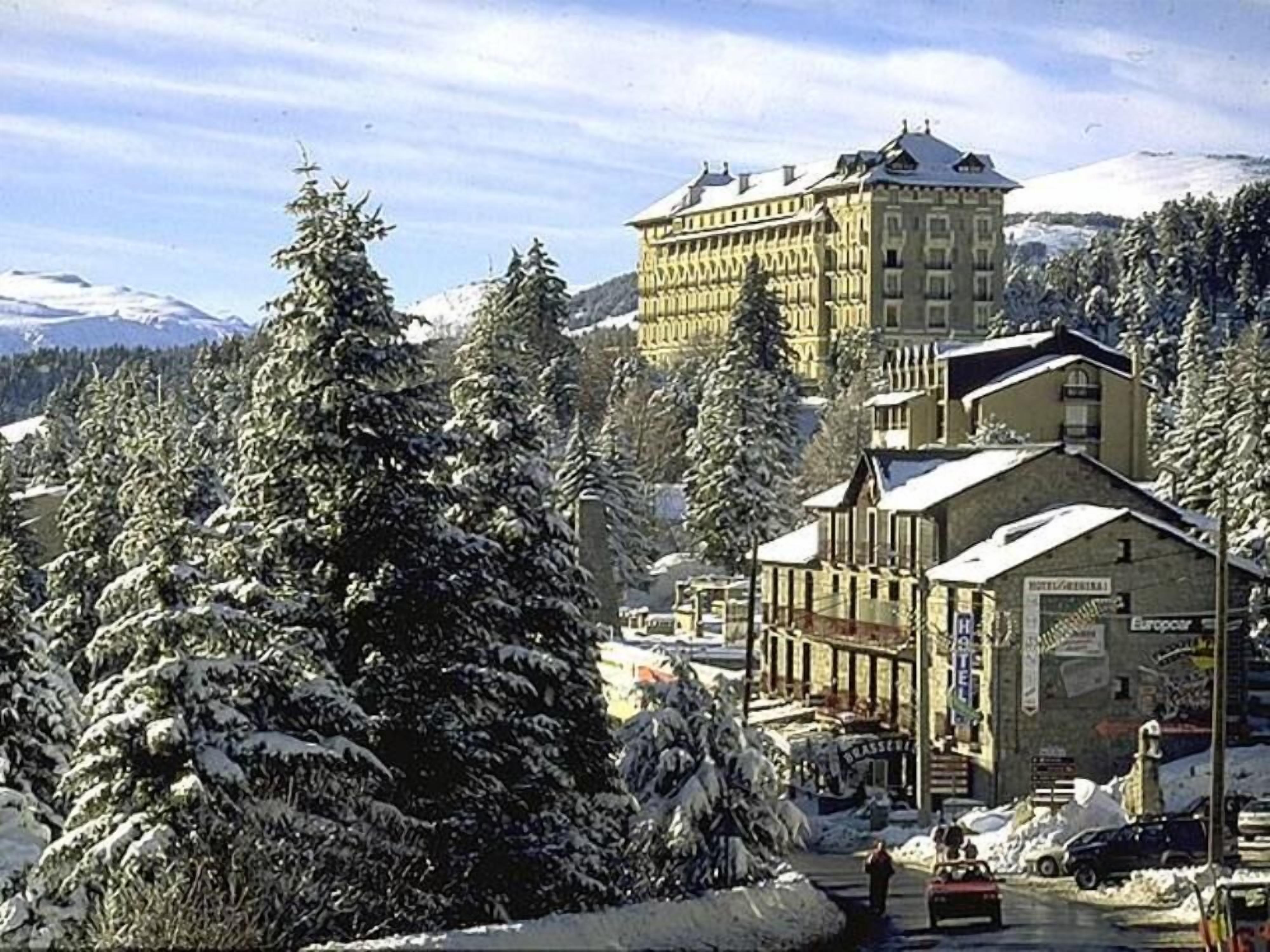 Un hotel de estilo arquitectónico europeo tradicional, con un edificio destacado que cuenta con una torre y numerosas ventanas.