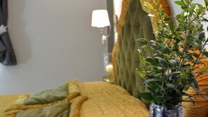 Una habitación de hotel con una cama, una lámpara y un florero con una planta.