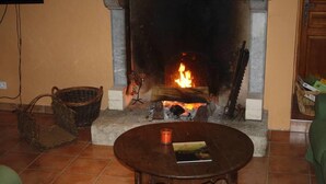 A living room with a fireplace, a round wooden table with a book and candle, and wicker baskets on the floor. - House / Villa - Trélou sur Marne (Trélou-Sur-Marne)