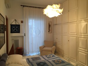 Relax in this stylish bedroom with a large bed, armchair, and classic wardrobe.