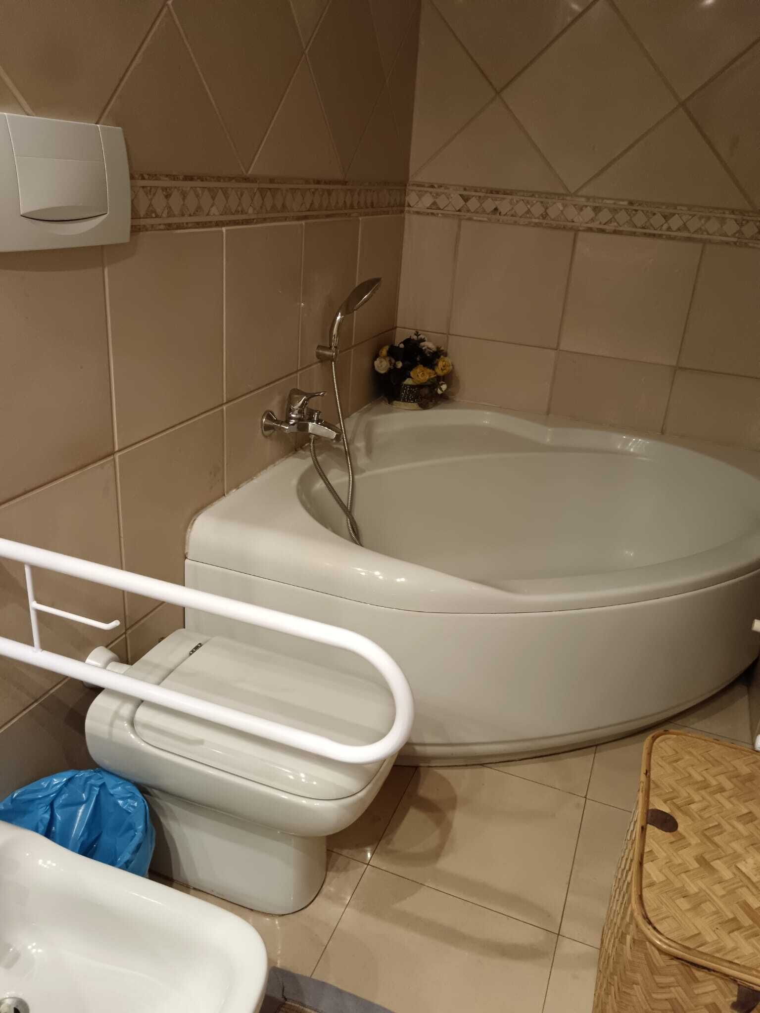 A bathroom with a bathtub, toilet, and bidet.