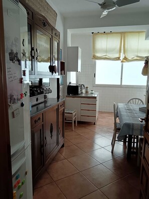 Une cuisine équipée d’un réfrigérateur, d’une cuisinière, d’un four à micro-ondes et d’une table à manger avec des chaises.
