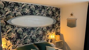 A bedroom with a bed, two bedside tables, a wall-mounted light fixture, and a star decoration.