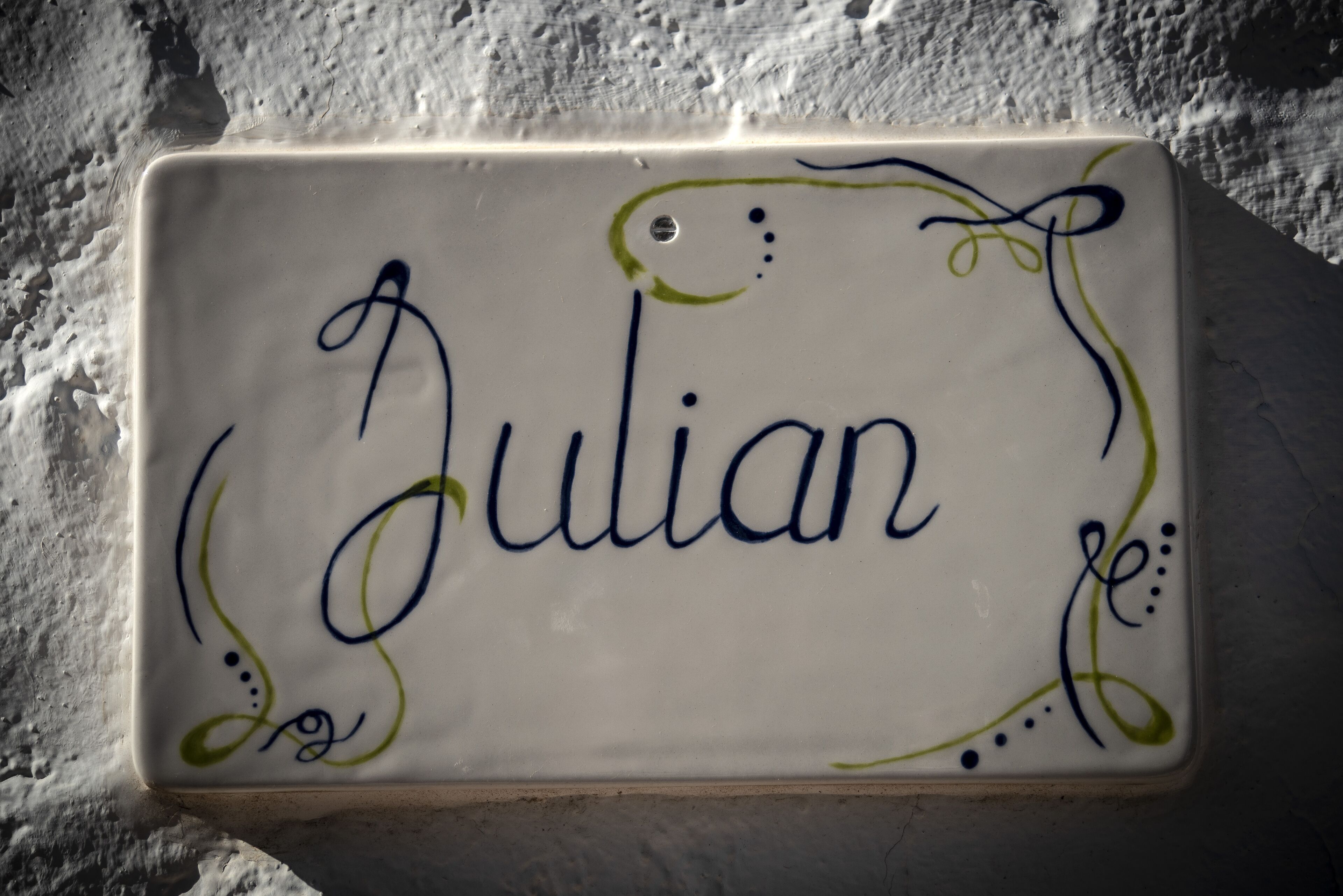Ein rechteckiges Keramikfliesen mit dem Namen Julian in Schreibschrift.