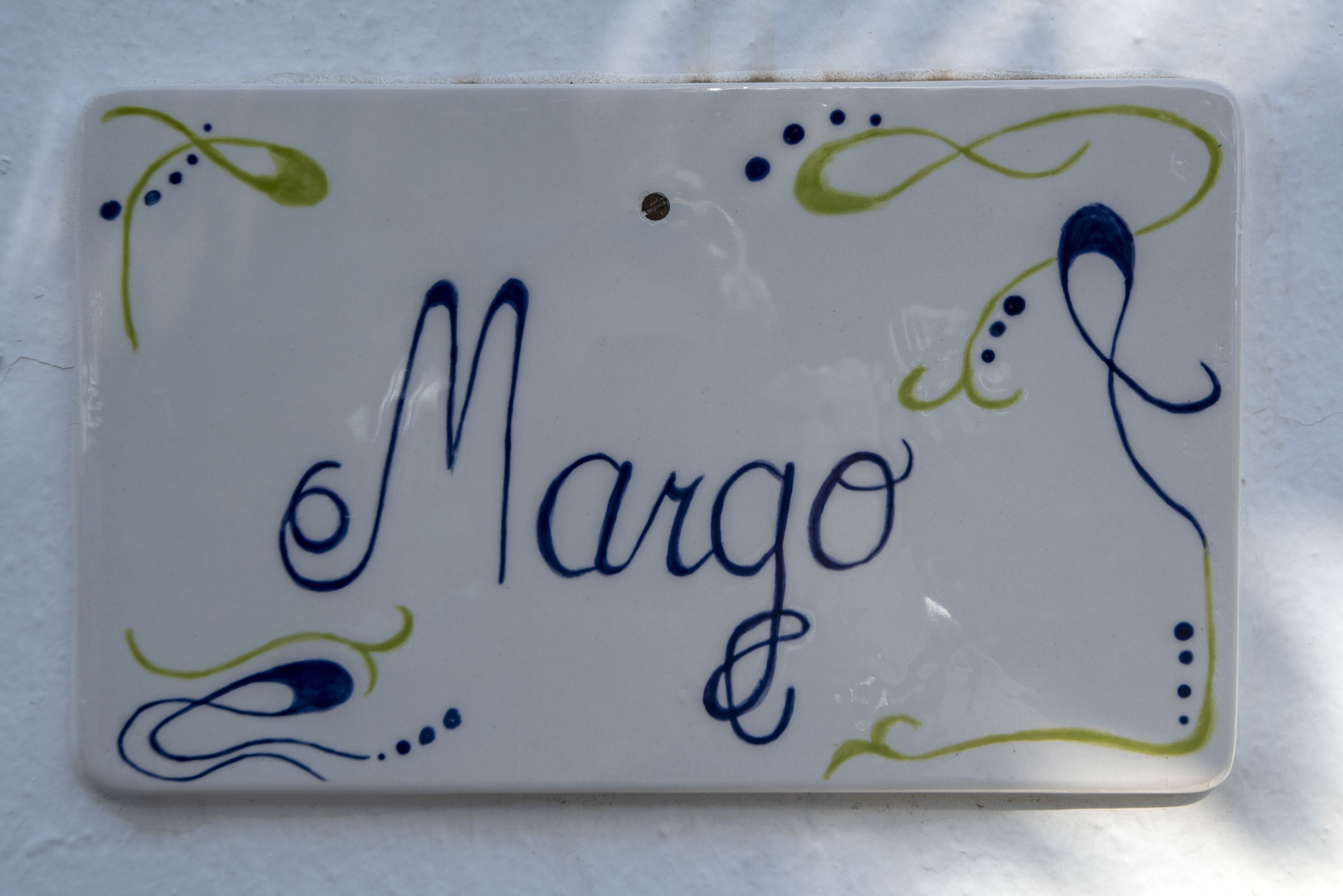 A ceramic tile with the name "Margo" in cursive.