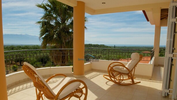 A balcony with two wicker chairs and a view of a green landscape and mountains. - Fantastic villa with a swimming pool ideal for a relaxing vacation and more... (Messini, Messinia)