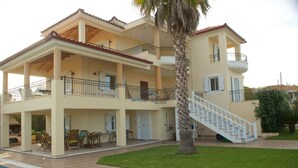 A multi-story building with a swimming pool, outdoor seating, and a staircase. - Fantastic villa with a swimming pool ideal for a relaxing vacation and more... (Messini, Messinia)