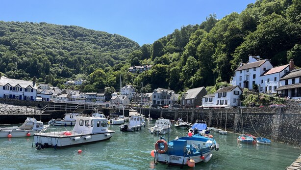 A harbor with boats docked, surrounded by buildings and a hillside. - Large Period House set in Ancient Woodland in Exmoor National Park near Lynmouth (Lynton)