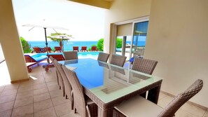Enjoy a meal with a view of the ocean and lush surroundings from this poolside dining area.