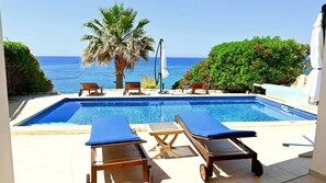Relax by the oceanfront pool surrounded by a tranquil atmosphere and lush greenery.