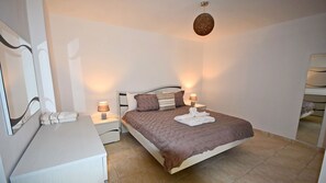 Cozy retreat with a neatly made bed, two bedside tables, and a large mirror.