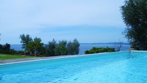 A clear blue pool with a view of the sea and greenery. - 'Stunning Views': beachfront villa with pool (Garda)
