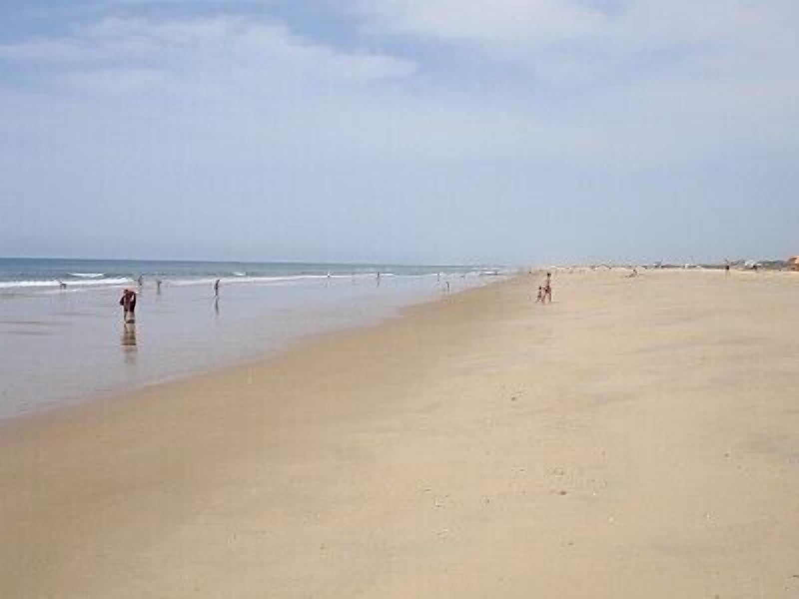 A wide, sandy beach with a clear sky.