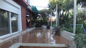 A covered outdoor area with steps leading to a patio, benches, and a view of the surrounding greenery. - Villa villa lLa Serreta (Alicante)