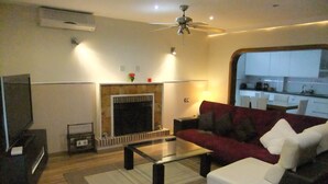 A living room with a fireplace, sofa, coffee table, and a television. - Villa villa lLa Serreta (Alicante)