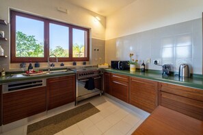 Una cocina moderna con horno empotrado, microondas y lavabo.