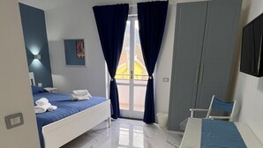 Ein Hotelzimmer mit einem Bett, einem Schreibtisch, einem Stuhl, einem Kleiderschrank und einem Fernseher.