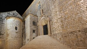 A stone building with a staircase leading to a dark entrance. - MODERN 1 BEDROOM APARTMENT - 100 mtrs from the beach, free parking, WIFI... (Dubrovnik)