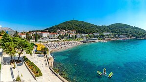 A coastal town with a beach, clear blue water, and a hill in the background. - MODERN 1 BEDROOM APARTMENT - 100 mtrs from the beach, free parking, WIFI... (Dubrovnik)