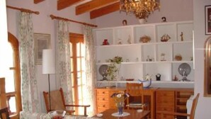 A dining area with wooden furniture, a chandelier, and decorative items on shelves. - sun and field (with wifi)  (Ariany)