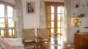 A cozy room with a wooden sofa, two chairs, a small table with a vase of flowers, and a cabinet. - sun and field (with wifi)  (Ariany)