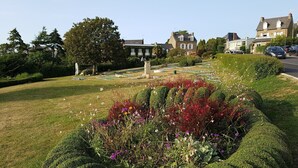 A well-maintained garden with a variety of flowers and neatly trimmed hedges. - Authentic Captain's house in the long courtyard of the late 19th century (Saint-Briac-Sur-Mer)