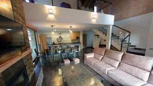 A modern living room with a glass coffee table, a sofa, a fireplace, and a staircase leading to an upper level. - Self catering La Puerta del Rio Lobos for 10 people (San Leonardo de Yague)