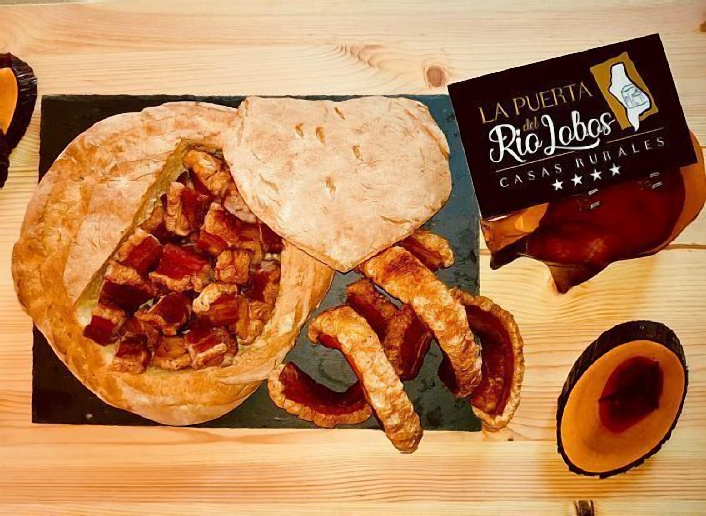 Una mesa con un pastel grande, un pedazo de pan plano y una botella de salsa.