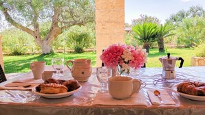 An outdoor dining table with plates of food, cups, and a flower arrangement. - Villa with private pool - sea view near WWF natural oasis (Carovigno)
