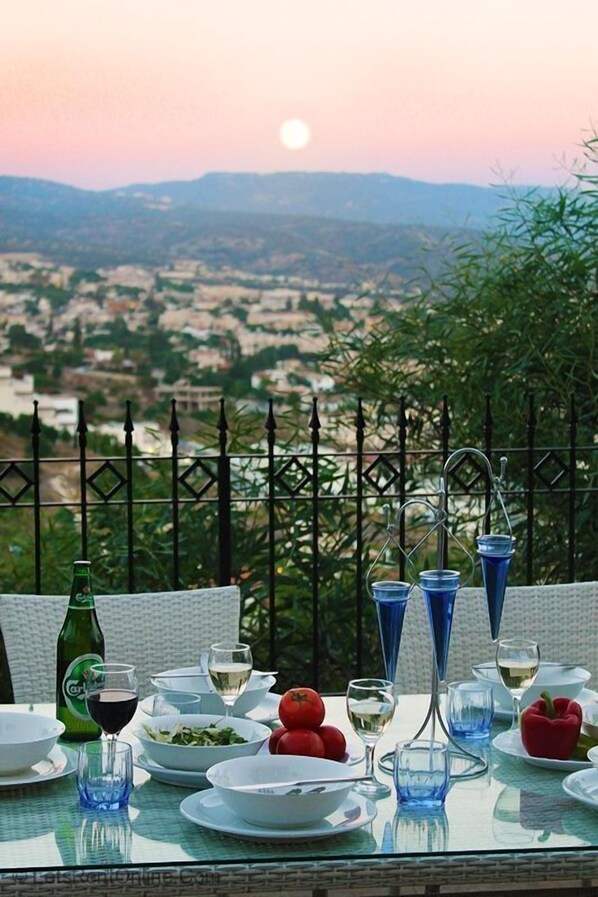 Une table dressée pour un repas, avec en arrière-plan un paysage.
